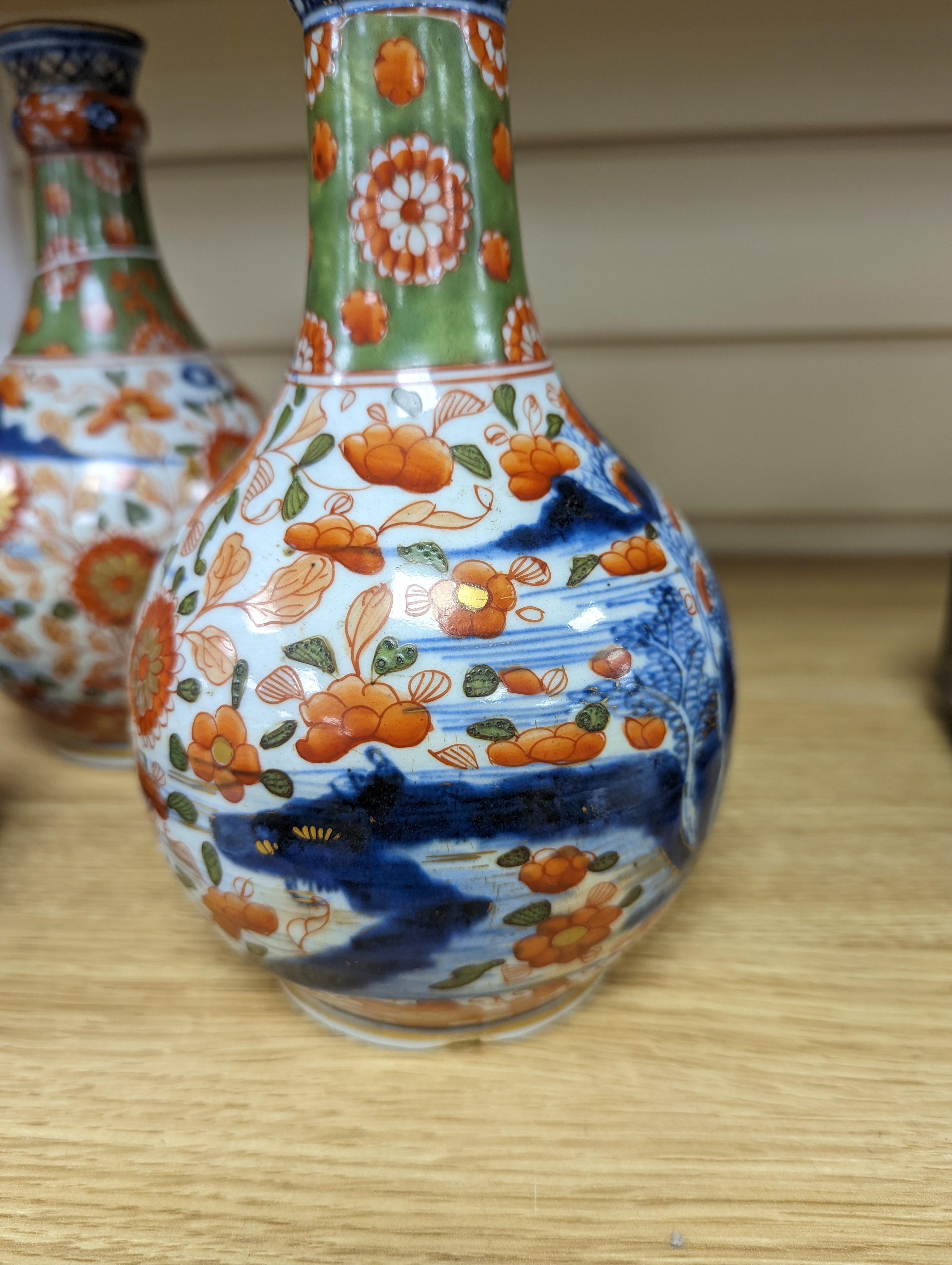 A pair of 18th century Chinese clobbered blue and white bottle vases 23cm